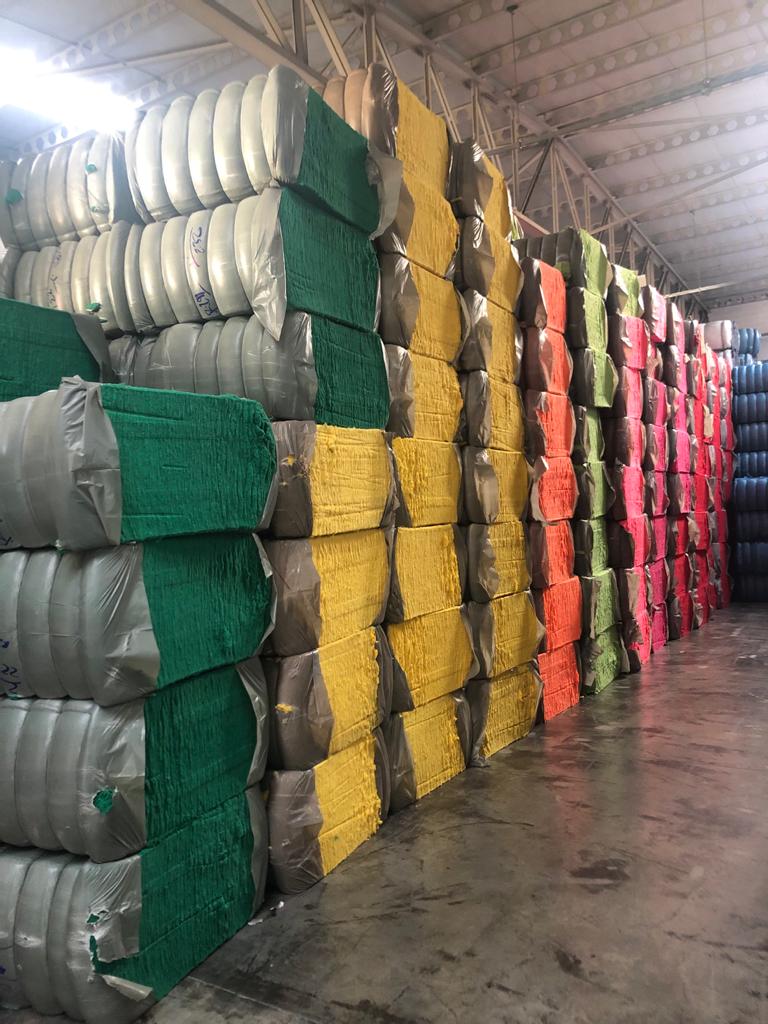 Colored shoddy fiber bales in a warehouse